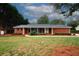 Well-maintained brick home with charming front porch, mature landscaping, and lush green lawn at 2533 Whispering Pines Dr, Grayson, GA 30017