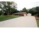 Expansive driveway leading to a brick home with a well-maintained lawn and mature trees at 2533 Whispering Pines Dr, Grayson, GA 30017