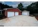 View of detached two-car garage with extra storage and a large cracked concrete driveway at 2533 Whispering Pines Dr, Grayson, GA 30017