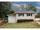 View of detached one-car garage with black shutters and manicured garden at 2533 Whispering Pines Dr, Grayson, GA 30017