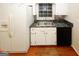 Kitchen features white cabinets, black appliances, and a stainless steel sink under a window at 2533 Whispering Pines Dr, Grayson, GA 30017
