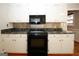 Kitchen featuring sleek black oven and microwave with white cabinets and dark countertops at 2533 Whispering Pines Dr, Grayson, GA 30017
