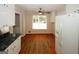 Kitchen with hardwood floors and white appliances and a view into adjacent room at 2533 Whispering Pines Dr, Grayson, GA 30017