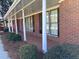 Inviting covered porch with white columns, adding charm to the red brick home exterior at 2533 Whispering Pines Dr, Grayson, GA 30017