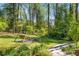 Lush, landscaped backyard featuring a swing set, fire pit, and verdant trees, perfect for outdoor relaxation and entertainment at 3325 N Embry Cir, Atlanta, GA 30341