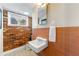 Bathroom with brick wall, sink, toilet, window and orange tiled accent wall at 3325 N Embry Cir, Atlanta, GA 30341