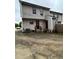 Backyard view of the home showcasing the exterior siding, rear entrance, and cracked asphalt at 3604 Hopkins Ct, Powder Springs, GA 30127