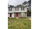 Two-story townhome with stone facade and red doors, nestled in a residential neighborhood at 3604 Hopkins Ct, Powder Springs, GA 30127
