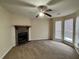 Spacious living room with a ceiling fan, fireplace, and large windows for natural light at 3604 Hopkins Ct, Powder Springs, GA 30127