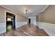 Formal dining room featuring elegant wainscoting, hardwood floors, and a modern chandelier at 609 Millstone Dr, Jonesboro, GA 30238