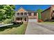 Charming two-story brick home featuring a covered porch, well-maintained lawn, and a long driveway leading to a two-car garage at 609 Millstone Dr, Jonesboro, GA 30238