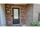 Inviting brick front door featuring a black door, a modern house number, and manicured greenery at 3084 Turman Cir, Decatur, GA 30033
