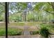 View of the front yard with a garden and walking path leading to a wooded area at 3085 Colonial Way # L, Atlanta, GA 30341