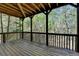 Spacious outdoor deck featuring natural wood floors, exposed wood beam ceiling, and wooded backyard at 320 Hillside Manor Dr, Sugar Hill, GA 30518