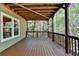 Spacious outdoor deck featuring natural wood floors, exposed wood beam ceiling, and wooded backyard at 320 Hillside Manor Dr, Sugar Hill, GA 30518