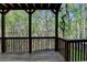 Spacious outdoor deck featuring natural wood floors, exposed wood beam ceiling, and wooded backyard at 320 Hillside Manor Dr, Sugar Hill, GA 30518