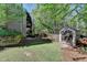 Backyard with a small deck, a fenced-in area, a storage shed and a playground at 320 Hillside Manor Dr, Sugar Hill, GA 30518