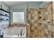 Bathroom featuring a soaking tub, tiled shower, and natural light at 320 Hillside Manor Dr, Sugar Hill, GA 30518