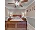 Cozy bedroom featuring crown molding, a ceiling fan, and bedside tables with lamps at 320 Hillside Manor Dr, Sugar Hill, GA 30518