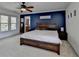 Spacious bedroom with a ceiling fan, accent wall, and large bed at 320 Hillside Manor Dr, Sugar Hill, GA 30518