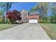 Charming two-story brick home featuring an attached two-car garage and manicured lawn at 320 Hillside Manor Dr, Sugar Hill, GA 30518