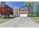 Charming two-story brick home featuring an attached two-car garage and manicured lawn at 320 Hillside Manor Dr, Sugar Hill, GA 30518