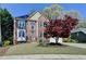 Charming two-story brick home with a well-manicured lawn and mature landscaping at 320 Hillside Manor Dr, Sugar Hill, GA 30518