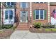 Front entrance of a brick home with green shutters and a well-maintained garden at 320 Hillside Manor Dr, Sugar Hill, GA 30518