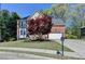Charming brick home with a well-manicured lawn and a beautiful tree in the front yard at 320 Hillside Manor Dr, Sugar Hill, GA 30518