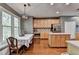 Well-lit kitchen boasts wood cabinets, stainless steel appliances, and an adjacent dining area with large windows at 320 Hillside Manor Dr, Sugar Hill, GA 30518