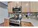 Close up of a modern kitchen with updated stainless steel gas range and microwave appliances at 320 Hillside Manor Dr, Sugar Hill, GA 30518
