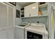 Functional laundry room featuring a washer, dryer, storage, and shelving at 320 Hillside Manor Dr, Sugar Hill, GA 30518