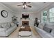 Cozy living room with a brick fireplace, plush sofas, and natural light from a large window at 320 Hillside Manor Dr, Sugar Hill, GA 30518