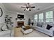 Inviting living room with a fireplace, comfortable seating, and large windows for natural light at 320 Hillside Manor Dr, Sugar Hill, GA 30518