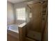 Bathroom featuring tile shower and soaking tub next to a large sunny window at 4036 Carlinswood Way, Stone Mountain, GA 30083