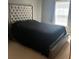 A serene bedroom features a modern bed with stylish tufted headboard and natural light from the window at 4036 Carlinswood Way, Stone Mountain, GA 30083