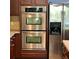 Close-up of modern stainless steel double ovens and a refrigerator in the kitchen at 4036 Carlinswood Way, Stone Mountain, GA 30083