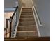 Carpeted staircase with dark wood banister and white railing, leading to the upper level of the home at 4036 Carlinswood Way, Stone Mountain, GA 30083
