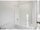 A white bathtub and shower combination in a bathroom with white walls and floors at 4185 Waterford Dr, Suwanee, GA 30024