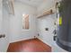 A compact laundry room features hardwood floors, a window, and an electric water heater at 4185 Waterford Dr, Suwanee, GA 30024