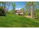 Spacious backyard with green grass, mature trees, and a charming home with deck at 388 Pine Trl, Canton, GA 30115