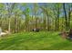 Expansive backyard featuring a lush green lawn and mature trees creates a serene and private outdoor space at 388 Pine Trl, Canton, GA 30115
