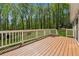 Stained wood deck with white railings offers scenic views of the yard and surrounding trees at 388 Pine Trl, Canton, GA 30115