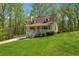 Charming cottage-style home with front porch, dormer windows, and a lush lawn surrounded by mature trees at 388 Pine Trl, Canton, GA 30115