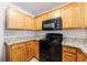 Charming kitchen with oak cabinets, granite counters, and black appliances at 6340 Hickory Lane Cir, Union City, GA 30291