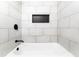 Modern bathroom with sleek white tiles, a built-in niche, and matte black fixtures at 3036 Crabapple Cir, Decatur, GA 30034