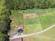 Aerial view of fenced pastureland with multiple paddocks and outbuildings on a bright day at 5187 Parkview Rd, Social Circle, GA 30025