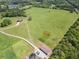 Expansive land with large grassy field, pond, home, barn, and outbuildings from an aerial view at 5187 Parkview Rd, Social Circle, GA 30025