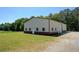Exterior view of the barn with a combination of white and brown finishing and a large garage door entrance at 5187 Parkview Rd, Social Circle, GA 30025