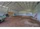 Interior of the metal barn with metal roof supports and a tractor parked inside at 5187 Parkview Rd, Social Circle, GA 30025
